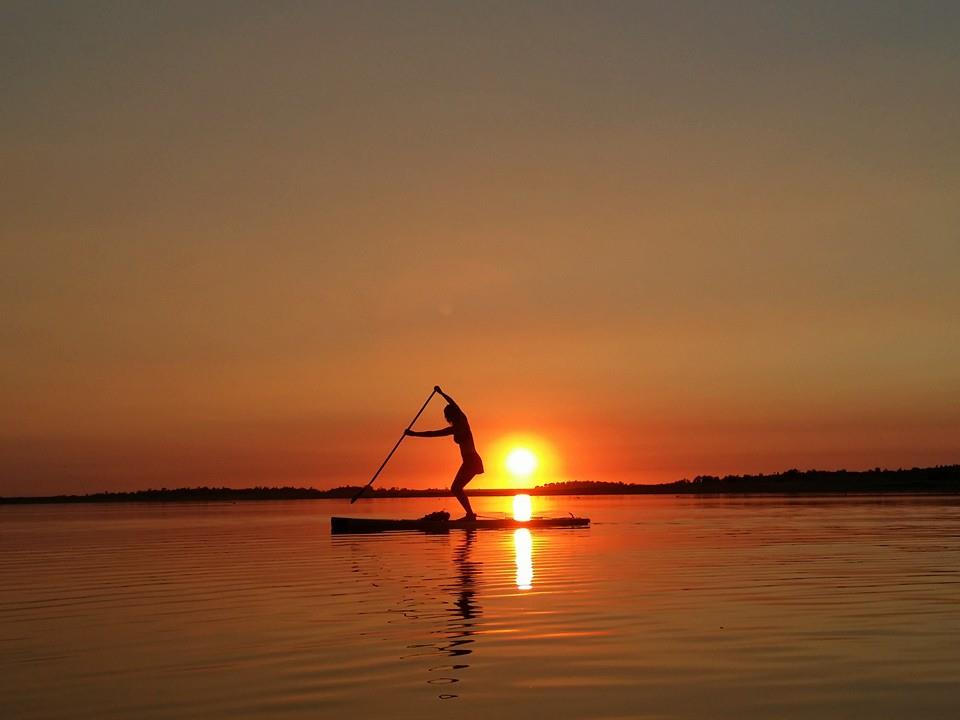 Padddler on SUP board in sunset